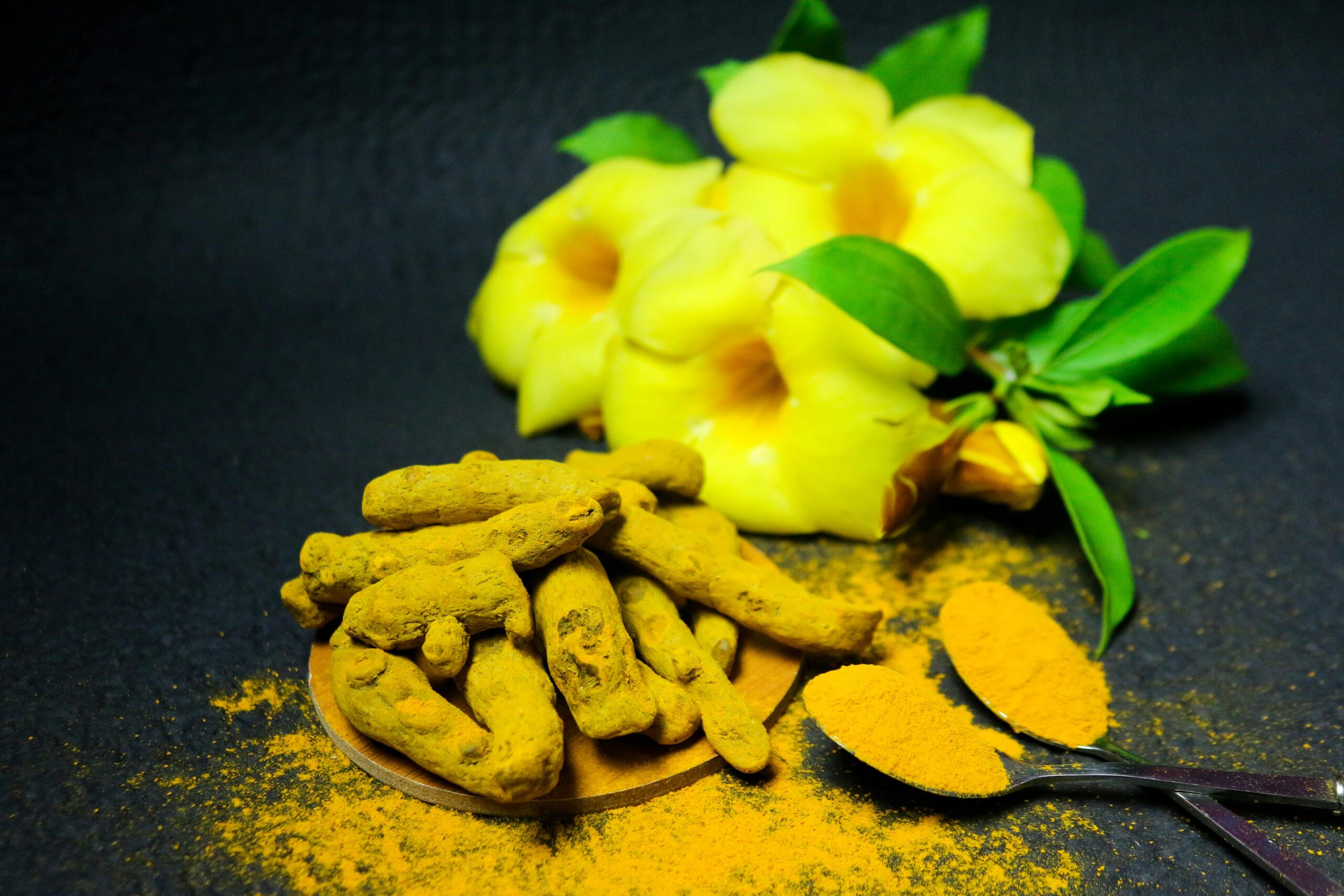 Fresh turmeric root and ground turmeric powder in a small bowl, representing a powerful anti-inflammatory food.
